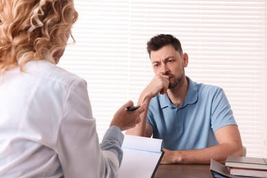 Doctor consulting patient at table in clinic