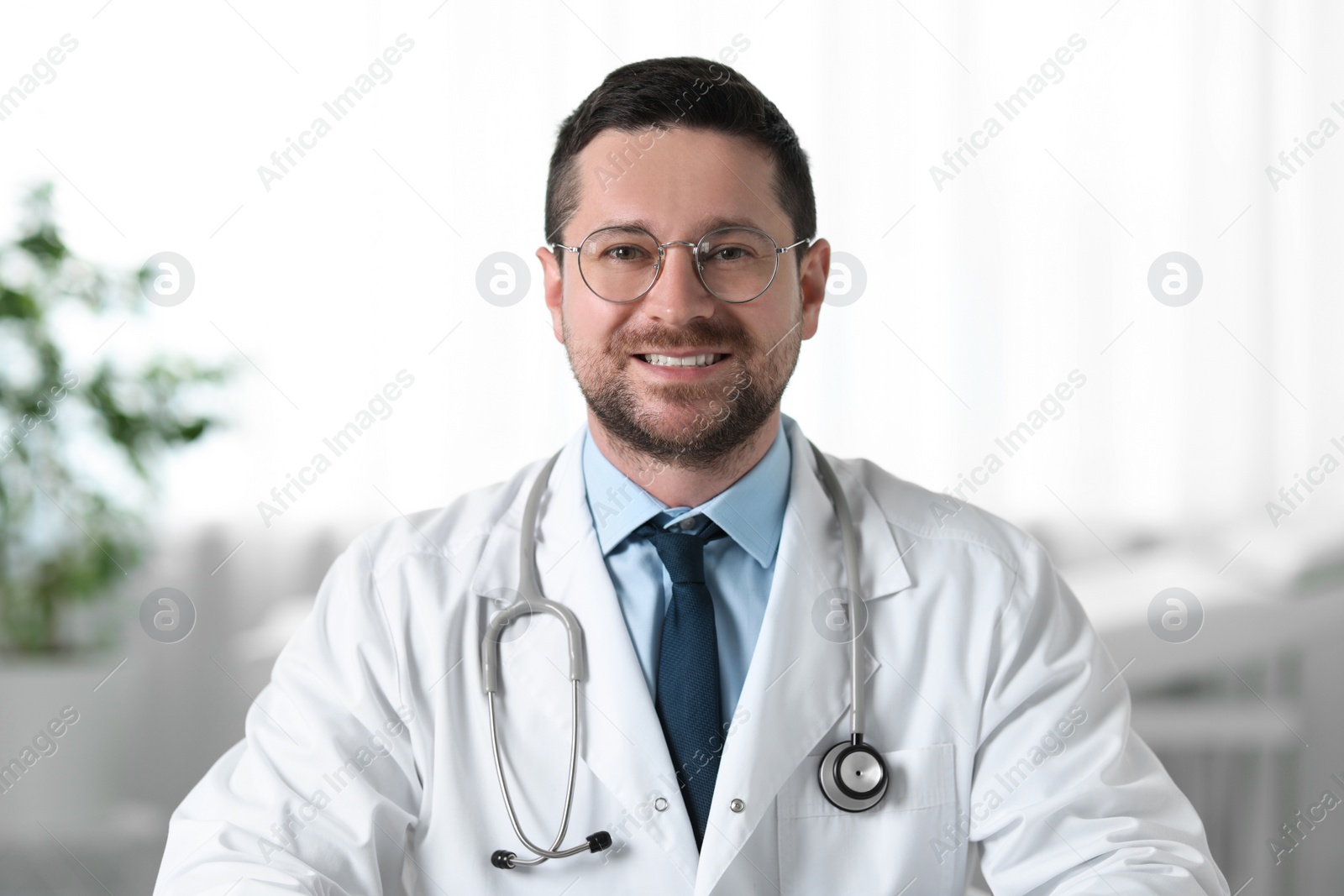 Photo of Portrait of smiling doctor with stethoscope in clinic