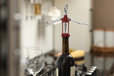 Photo of Wine bottle with metal corkscrew in kitchen