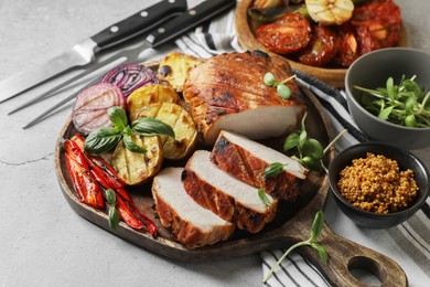 Photo of Delicious grilled meat and vegetables served on light grey table, closeup