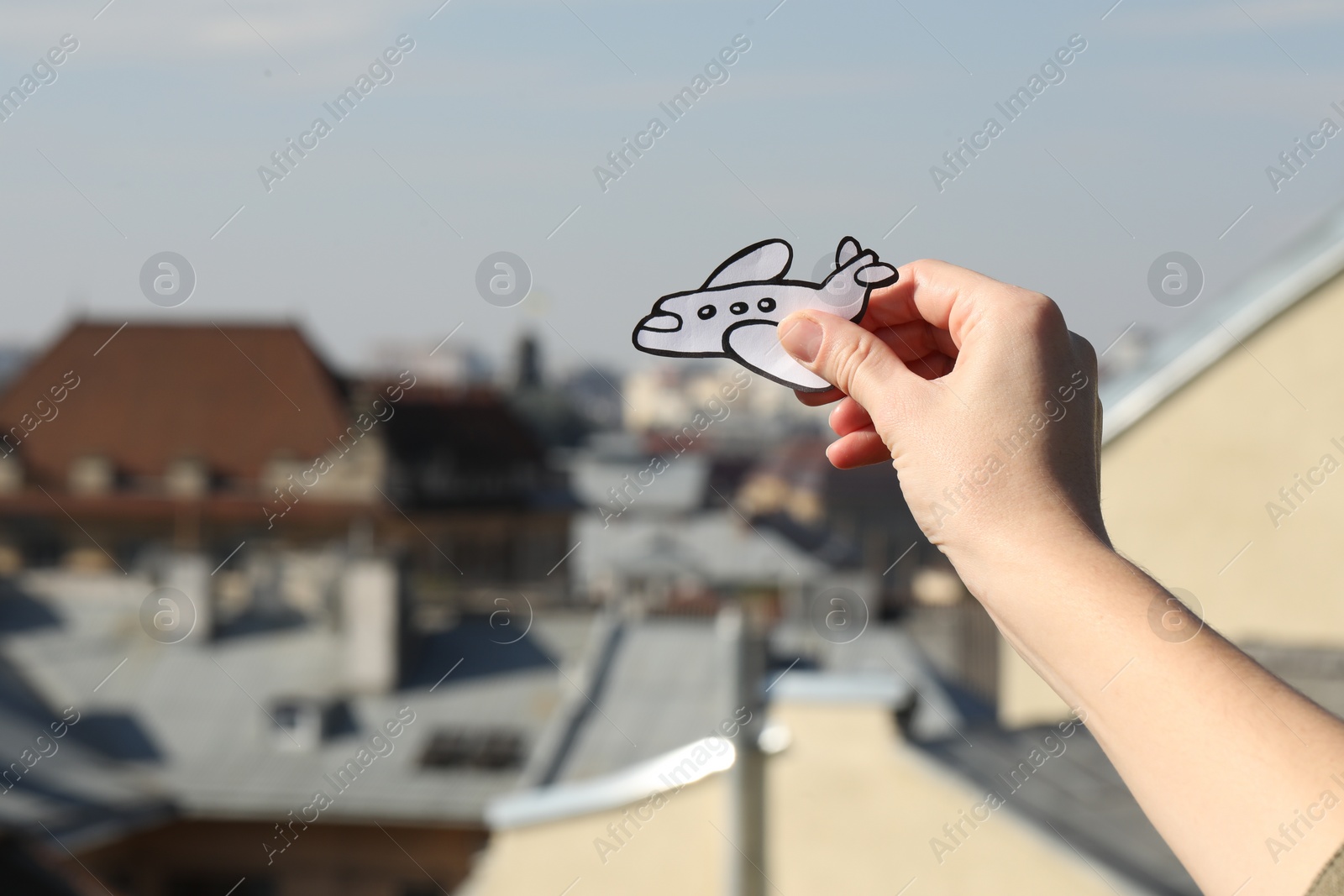 Photo of Woman holding paper plane outdoors, closeup. Space for text