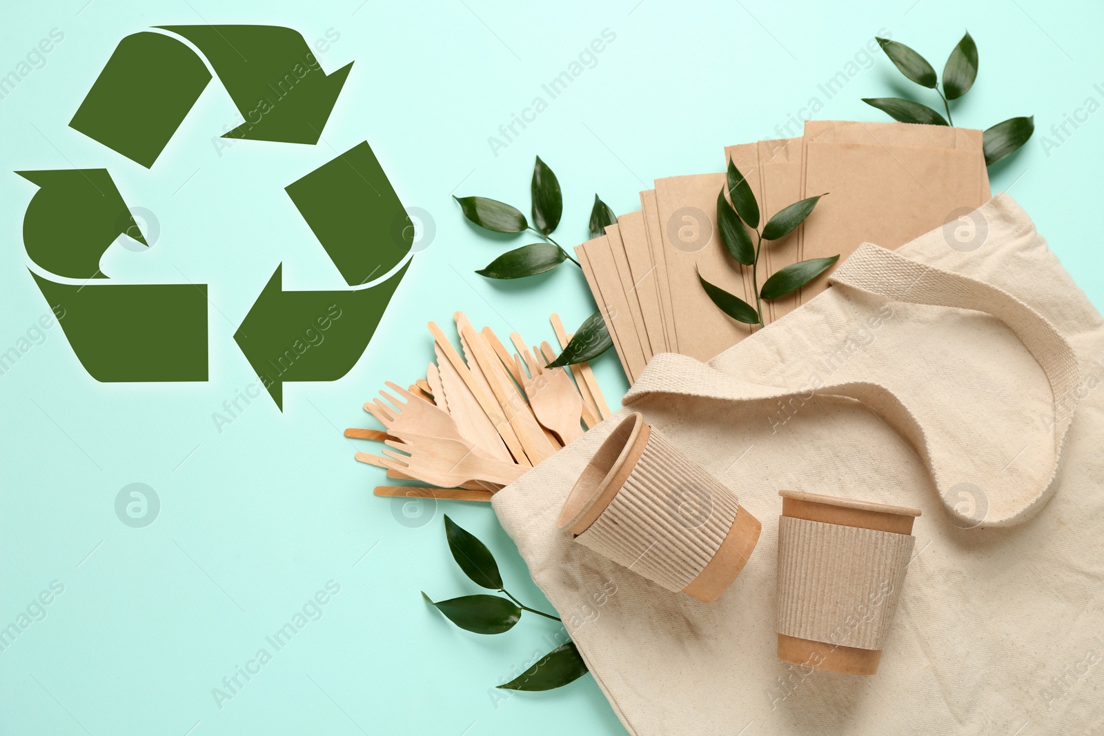 Image of Flat lay composition of eco friendly products and recycling symbol on light blue background