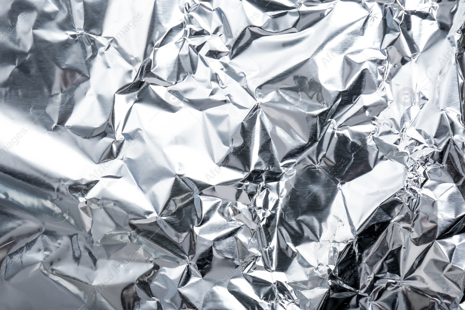 Photo of Crumpled silver foil as background, closeup view