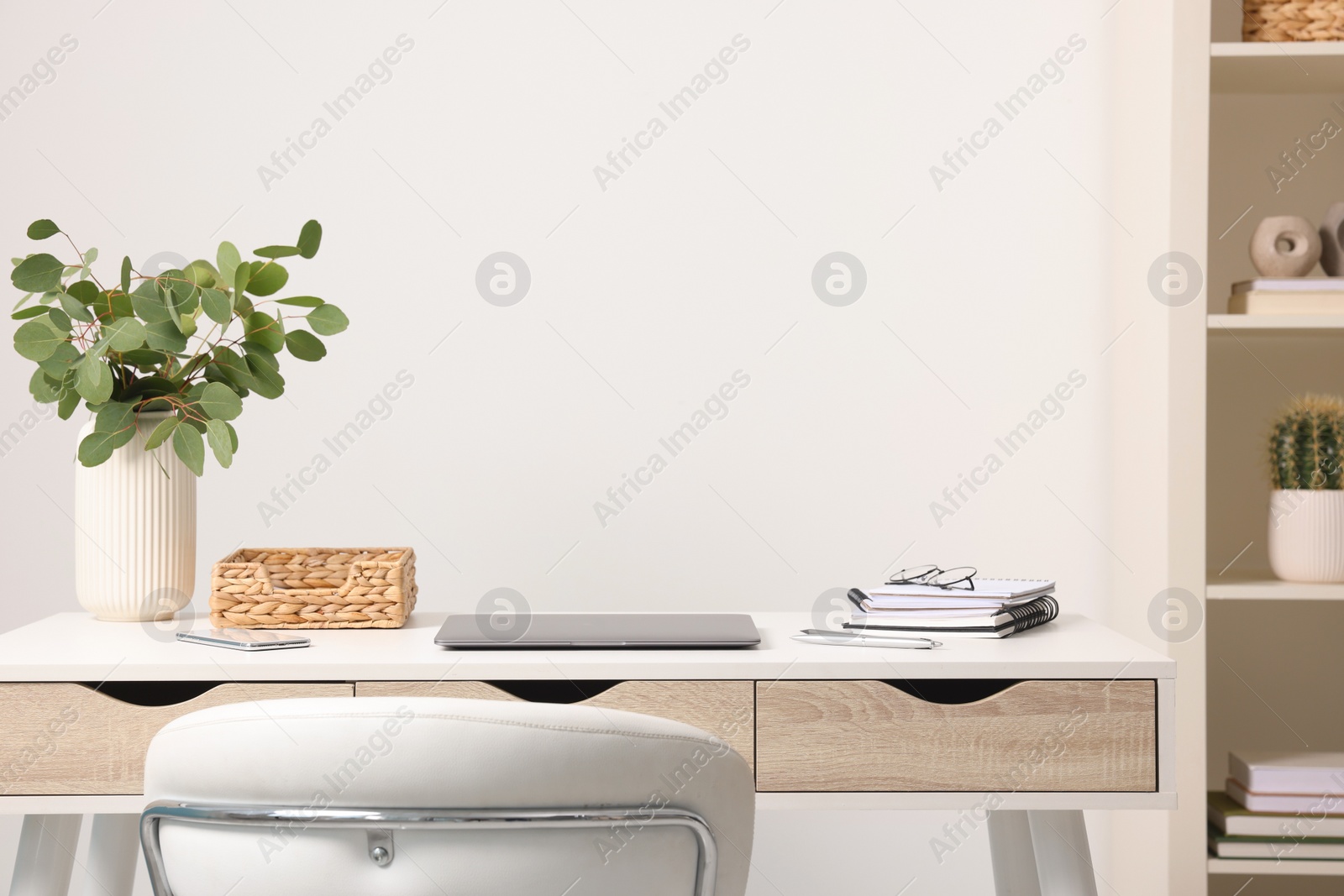 Photo of Home office. Laptop, glasses, stationery and plant on white desk indoors. Space for text