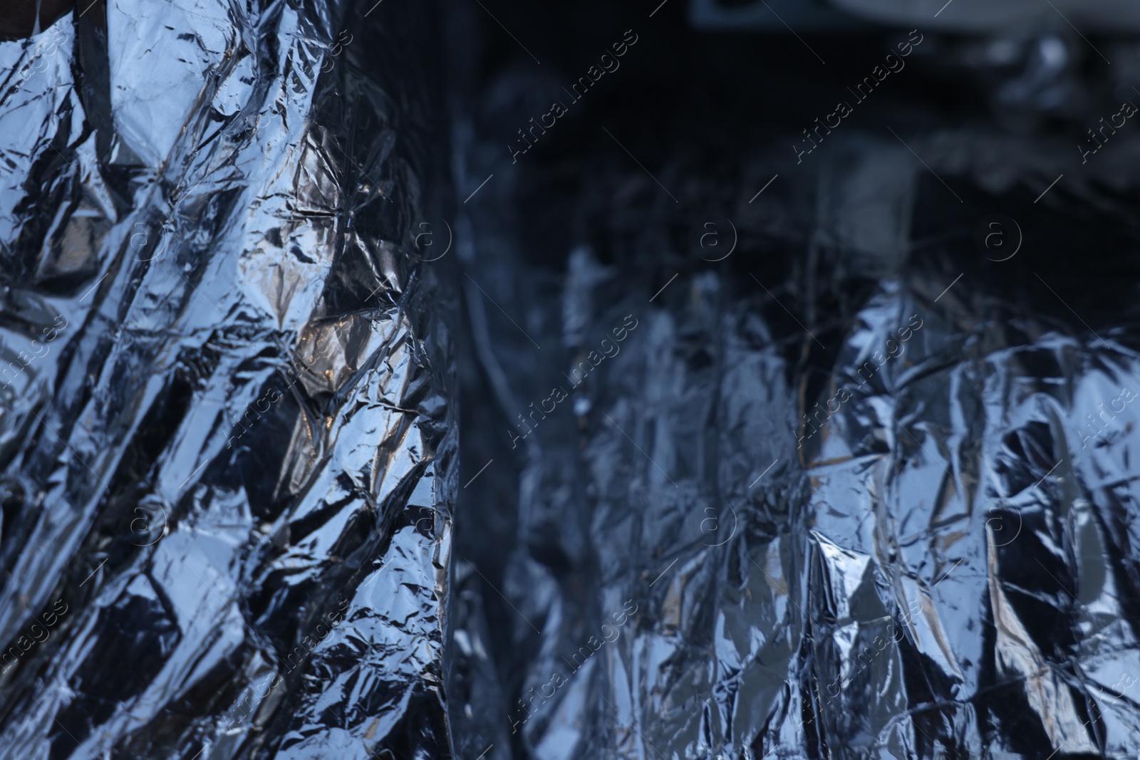 Photo of Texture of crumpled aluminum foil as background, closeup