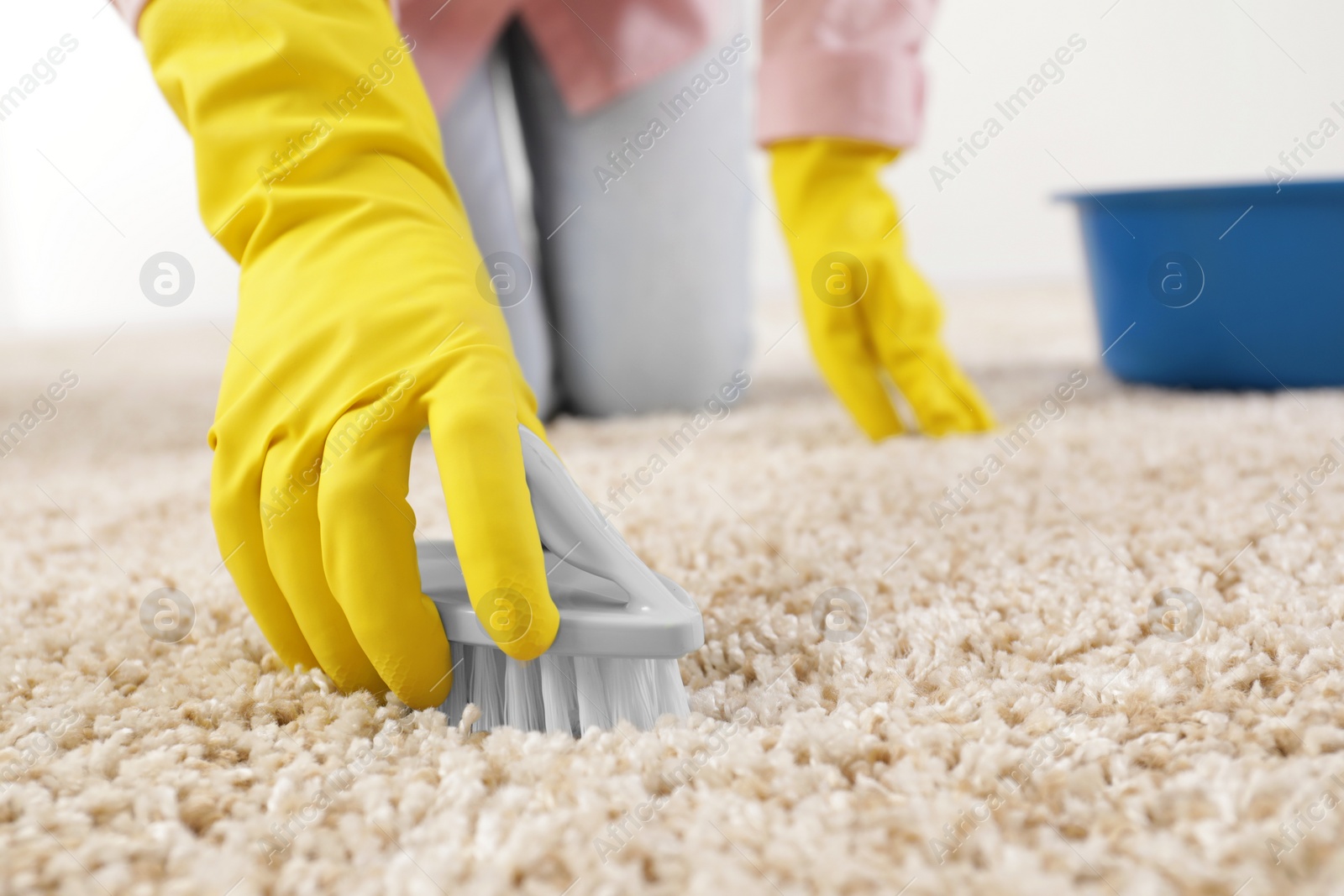 Photo of Woman cleaning carpet with brush indoors, closeup. Space for text