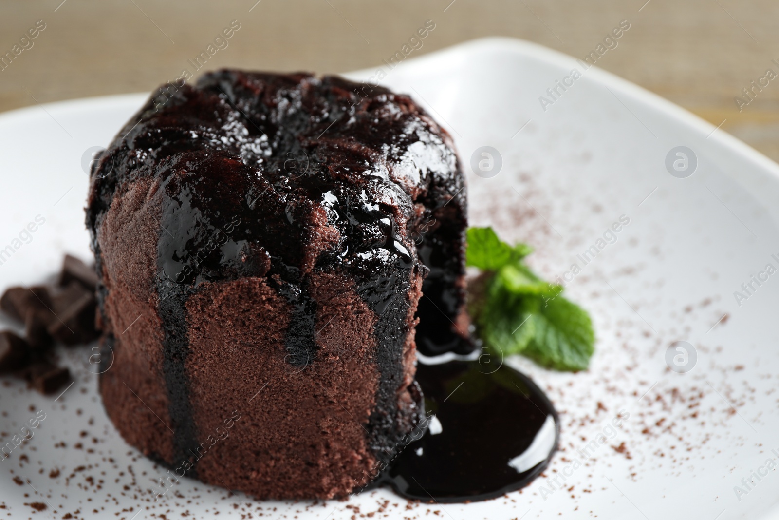 Photo of Delicious warm chocolate lava cake on plate, closeup