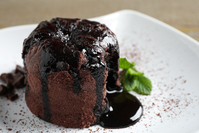 Photo of Delicious warm chocolate lava cake on plate, closeup