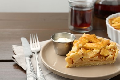 Photo of Piece of tasty homemade quince pie with ice cream on wooden table, closeup. Space for text