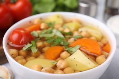 Photo of Tasty chickpea soup in bowl on table, closeup