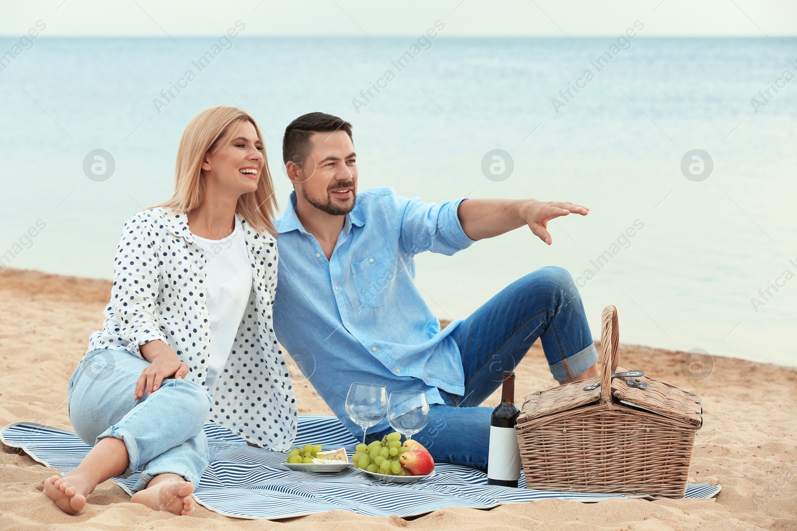 Photo of Happy romantic couple having picnic at beach