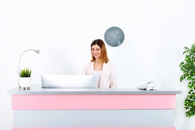 Photo of Beautiful woman working at reception desk in beauty salon