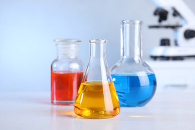 Photo of Different glassware with samples on table in chemistry laboratory