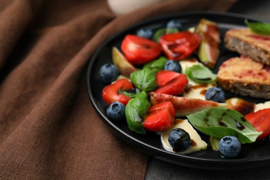 Photo of Delicious salad with brie cheese, berries and balsamic vinegar on table, closeup