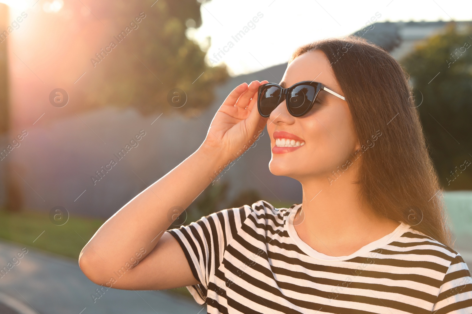 Photo of Beautiful smiling woman in sunglasses outdoors, space for text