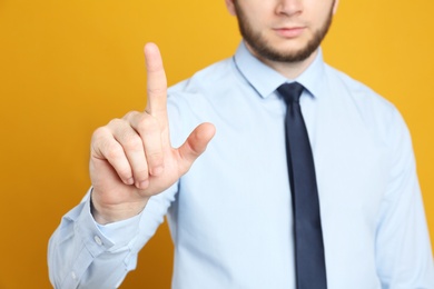 Photo of Businessman touching something against orange background, focus on hand
