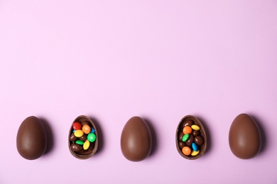 Photo of Flat lay composition with chocolate Easter eggs and space for text on color background