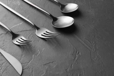 Photo of Beautiful cutlery set on black table, closeup. Space for text