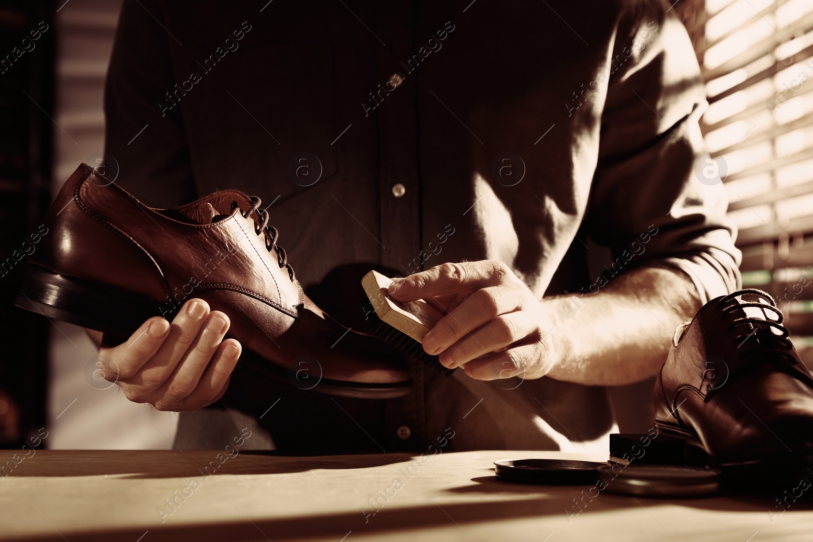 Image of Man taking care of shoes in workshop, closeup