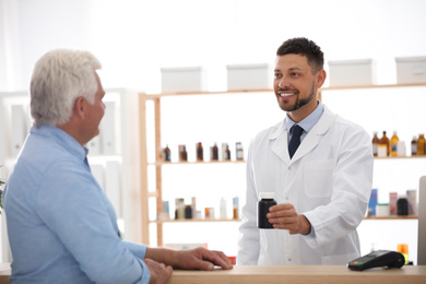Photo of Pharmacist giving medicine to customer in drugstore