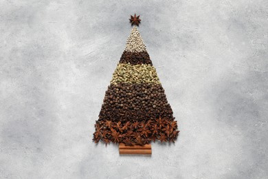 Photo of Christmas tree made of different spices on gray textured table, top view. Space for text