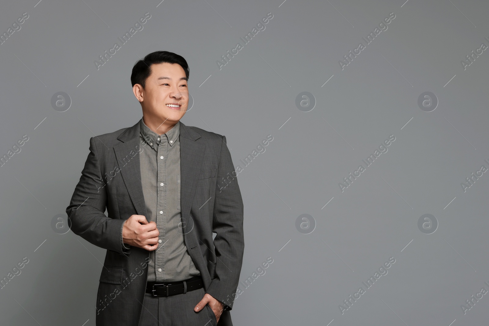 Photo of Portrait of happy businessman on grey background. Space for text