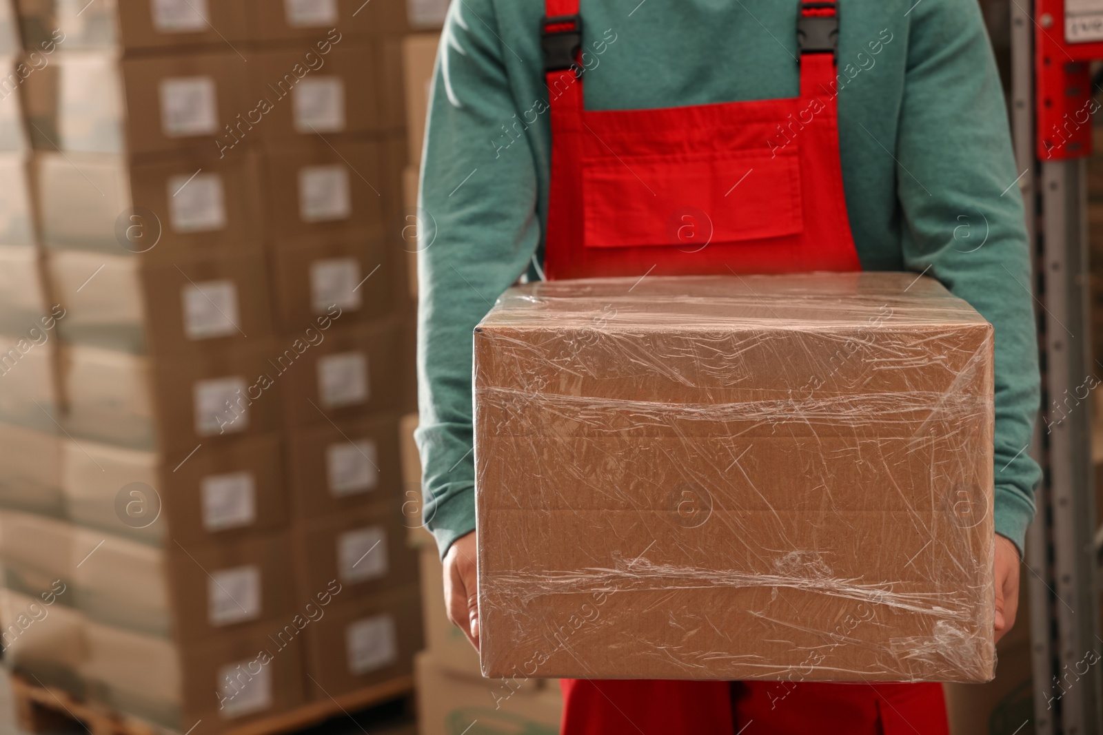 Photo of Worker with cardboard box in warehouse, closeup. Wholesaling