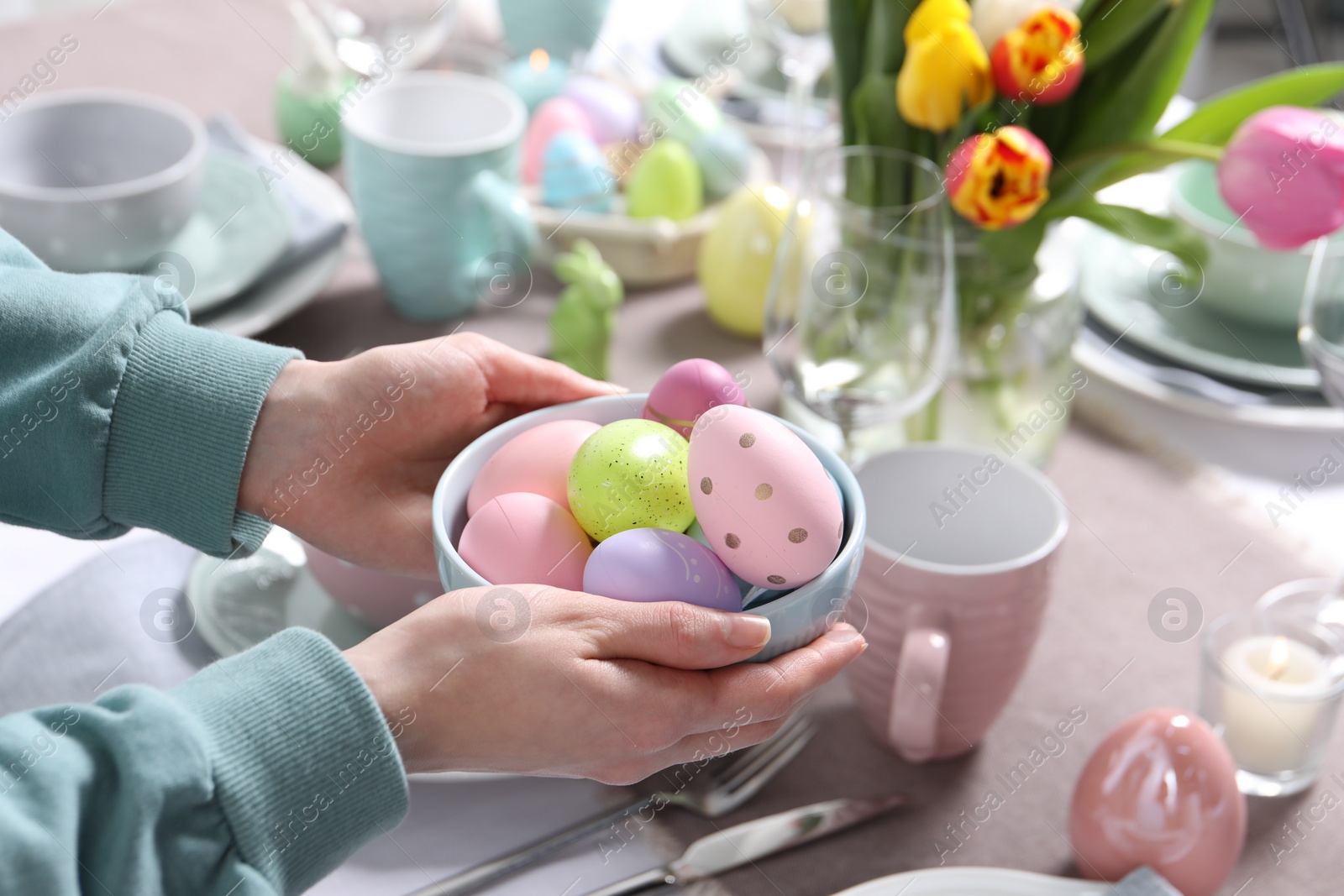 Photo of Woman setting table for festive Easter dinner at home, closeup