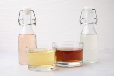 Photo of Different types of vinegar on light table, closeup