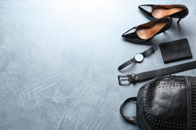 Photo of Flat lay composition with leather bag, shoes and accessories on light stone table. Space for text