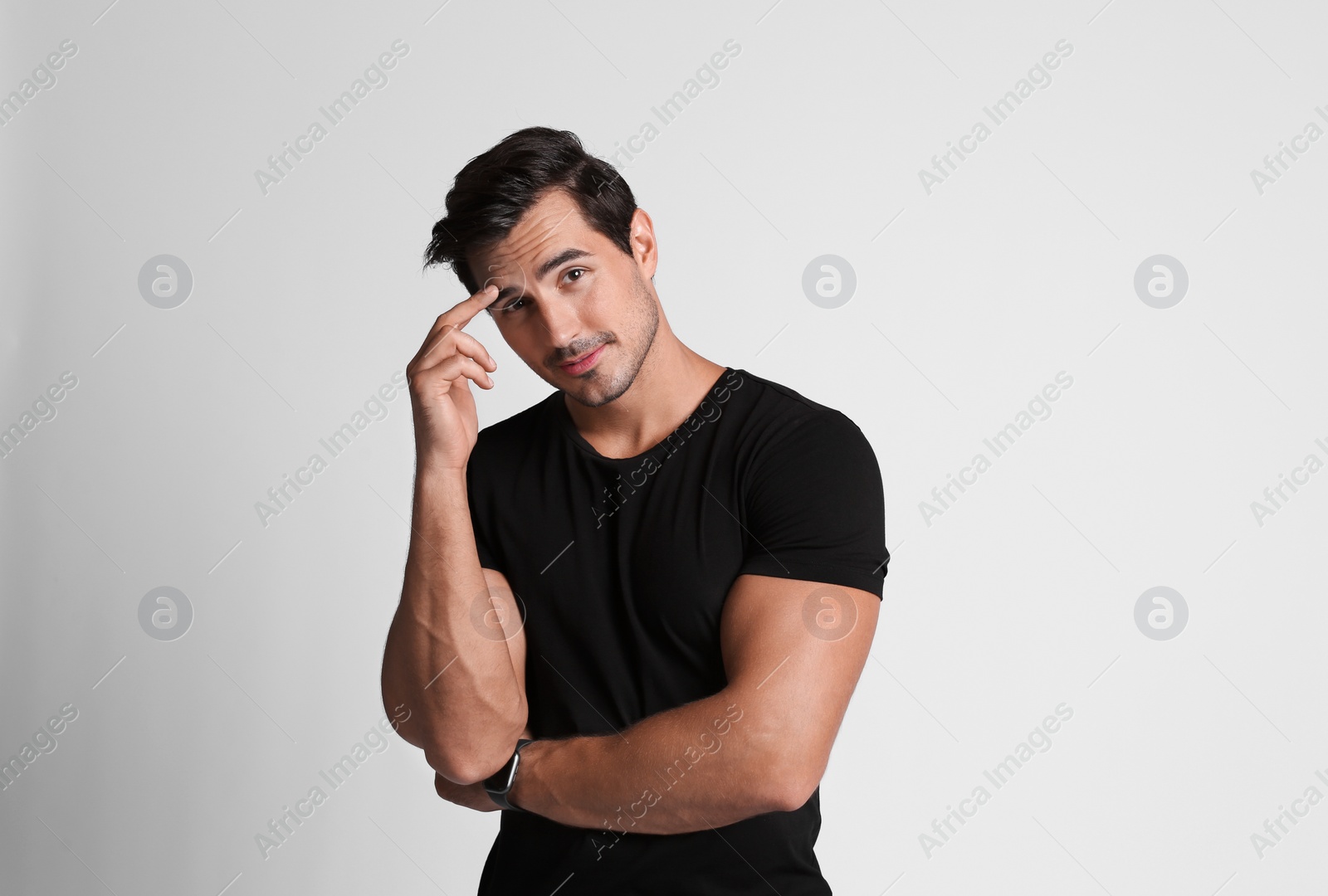 Photo of Portrait of handsome young man in black t-shirt on grey background