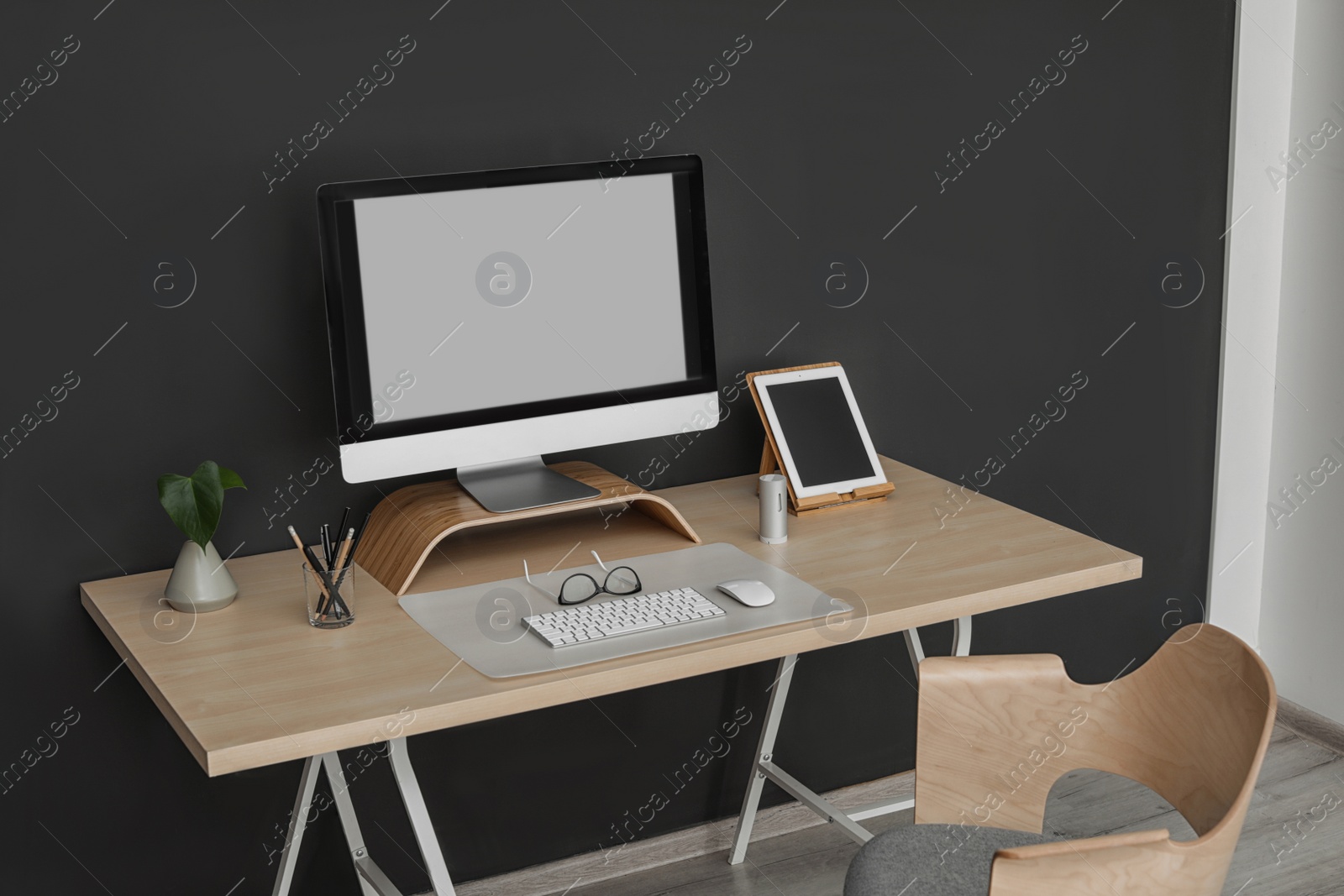 Photo of Modern workplace interior with computer on table. Space for text