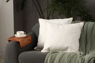 Soft white pillows and blanket on sofa indoors