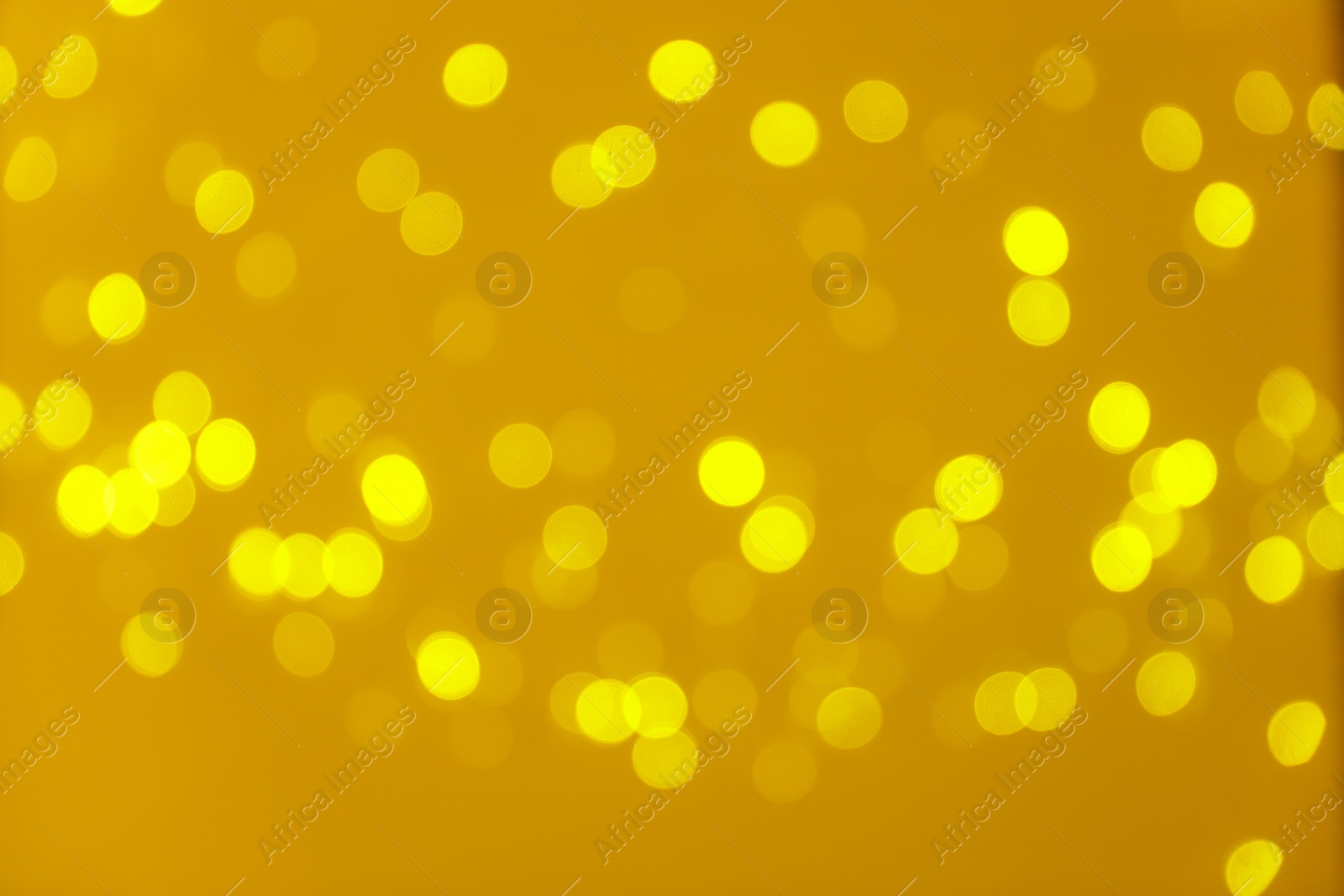 Photo of Blurred view of shiny gold lights. Bokeh effect