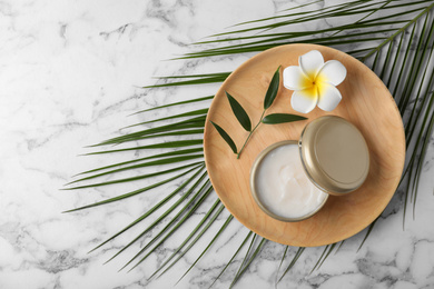 Photo of Composition with cosmetic product and tropical flower on white marble table, top view. Space for text