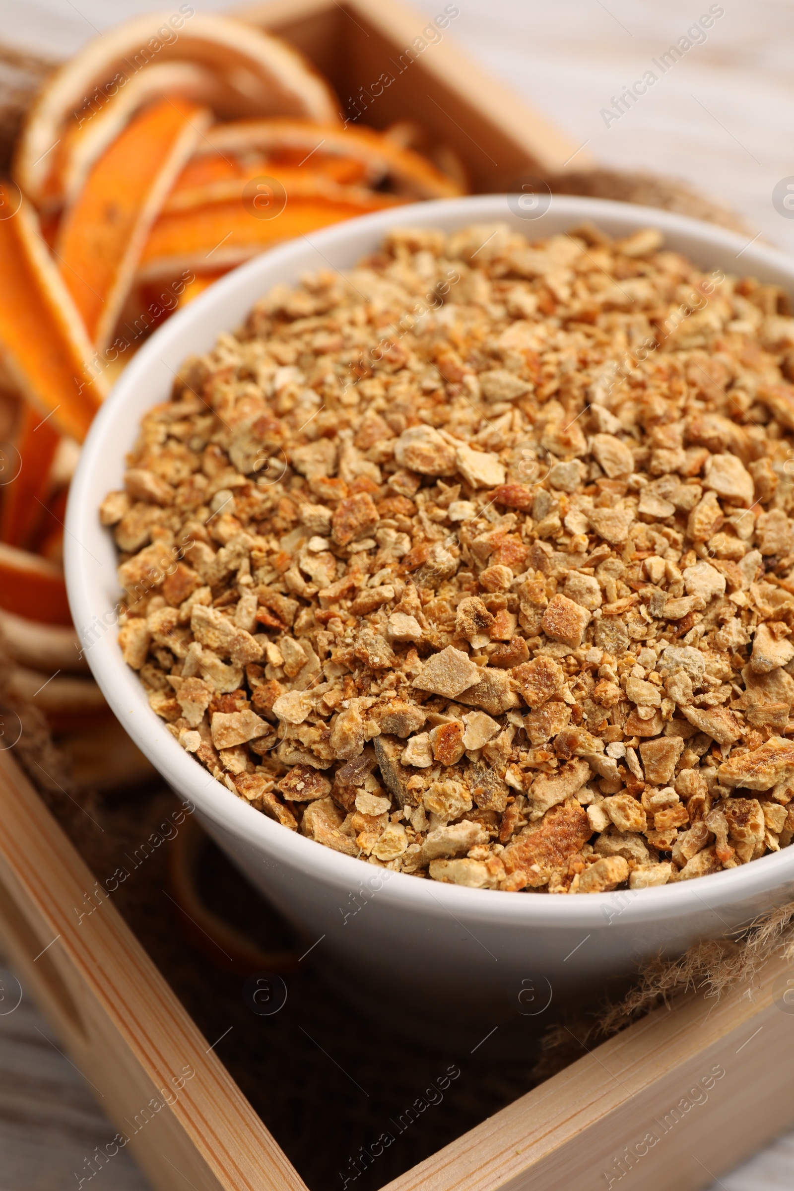 Photo of Dried orange seasoning zest and peel on white wooden table, closeup