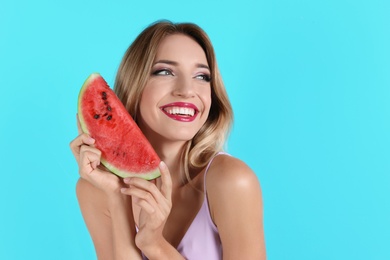 Pretty young woman with juicy watermelon on color background