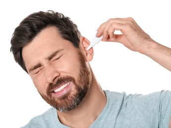 Man using ear drops on white background