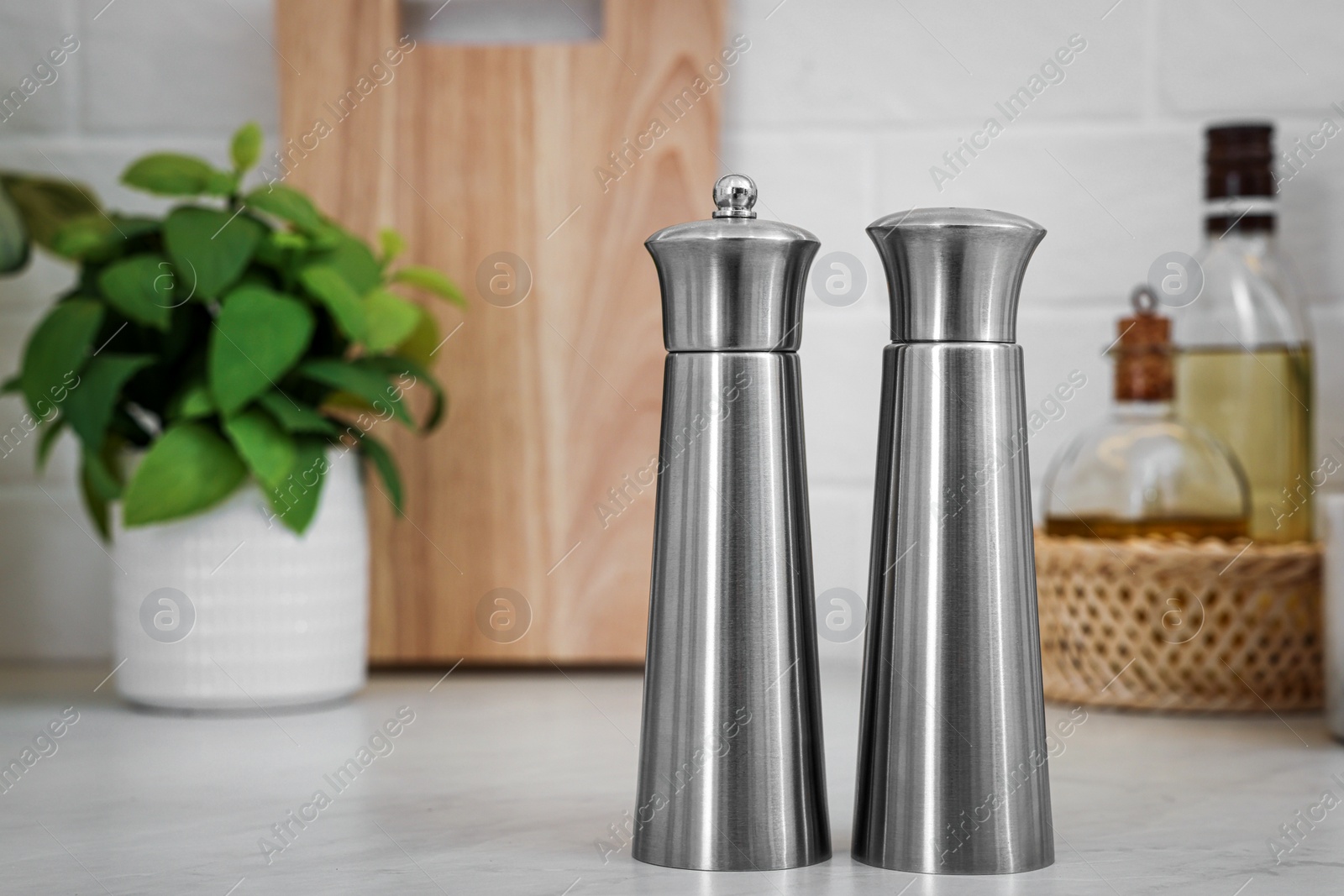 Photo of Stainless steel salt and pepper shakers on table, space for text