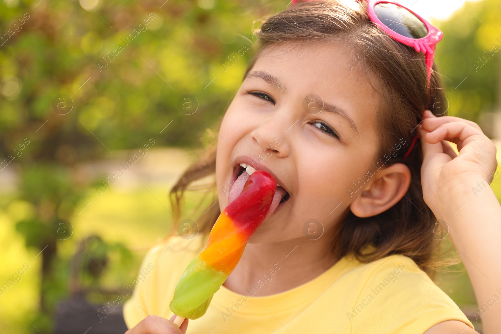 Photo of Cute little girl with delicious ice cream in park