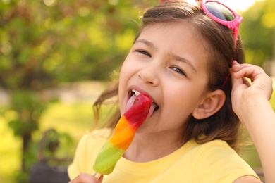 Photo of Cute little girl with delicious ice cream in park