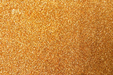 Photo of Beautiful shiny golden glitter as background, closeup