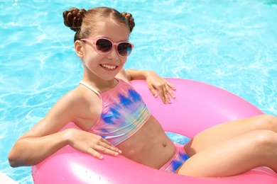 Little girl with inflatable ring in swimming pool