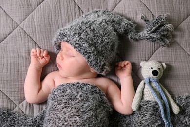 Cute newborn baby sleeping with toy in bed, top view