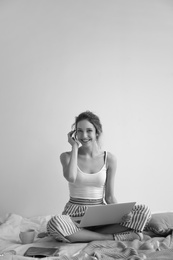 Photo of Female blogger with laptop on bed, black and white effect