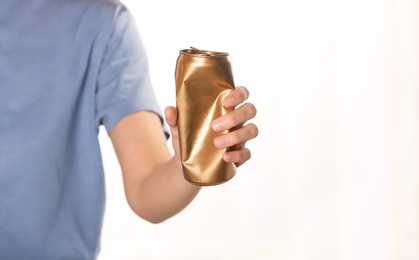 Photo of Woman holding crumpled aluminum can on blurred background. Metal waste recycling