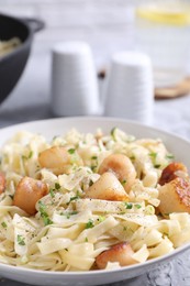 Photo of Delicious scallop pasta with spices in bowl on table, closeup