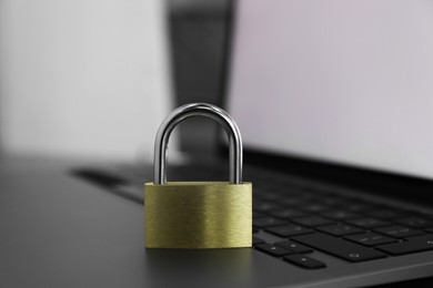 Cyber security. Metal padlock on laptop, closeup