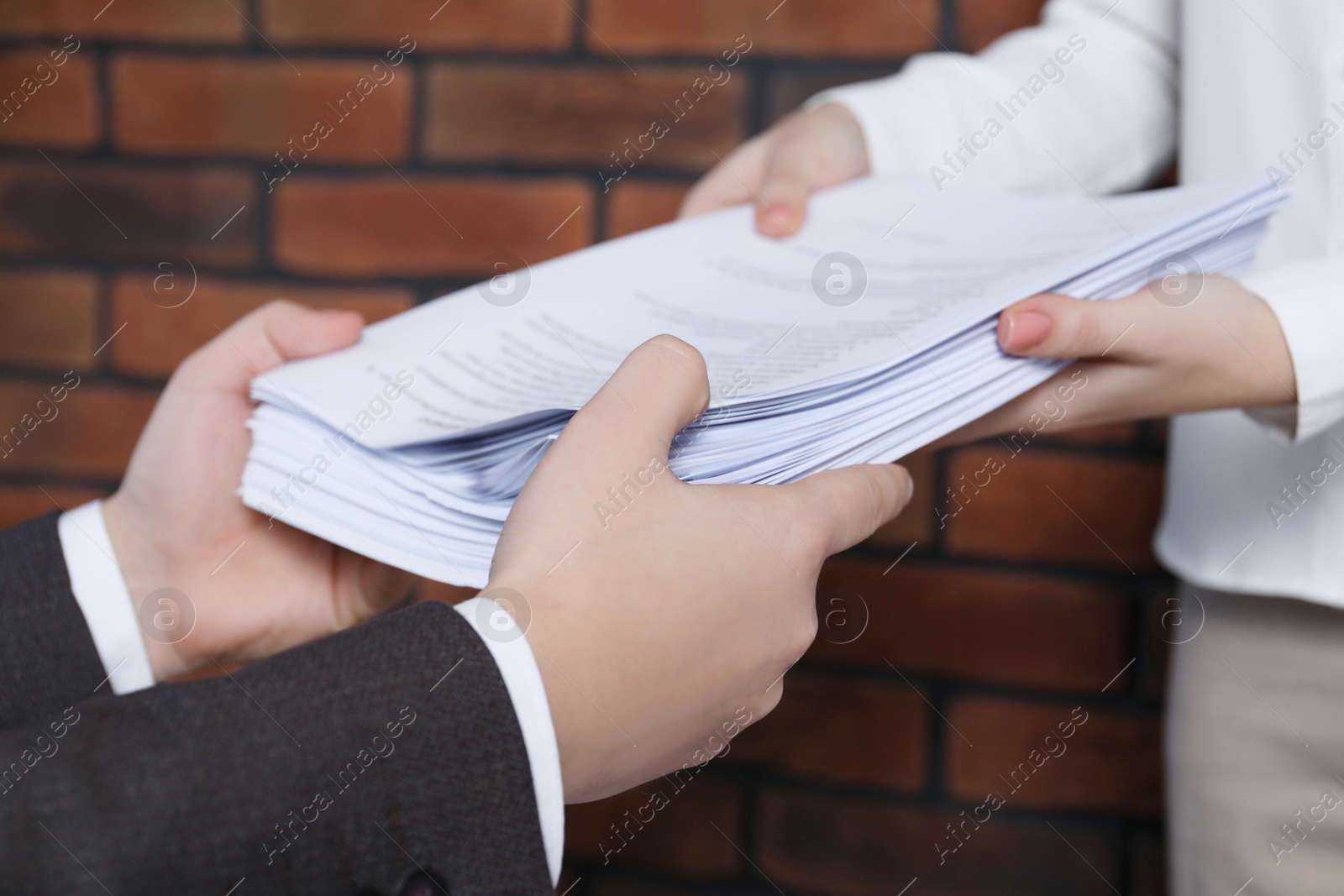 Photo of Woman giving many documents to man in office, closeup