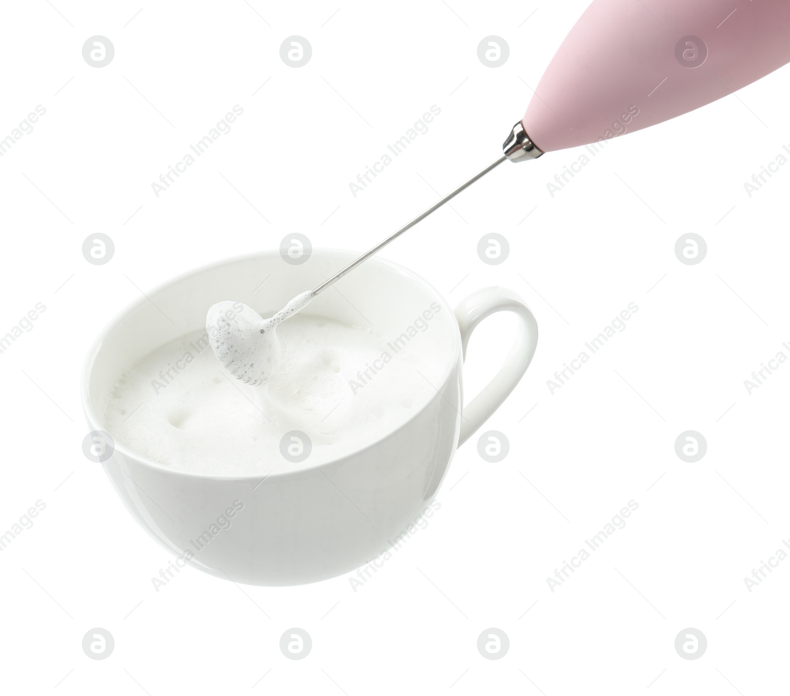 Photo of Whisking milk in cup with mini mixer (frother wand) isolated on white, closeup